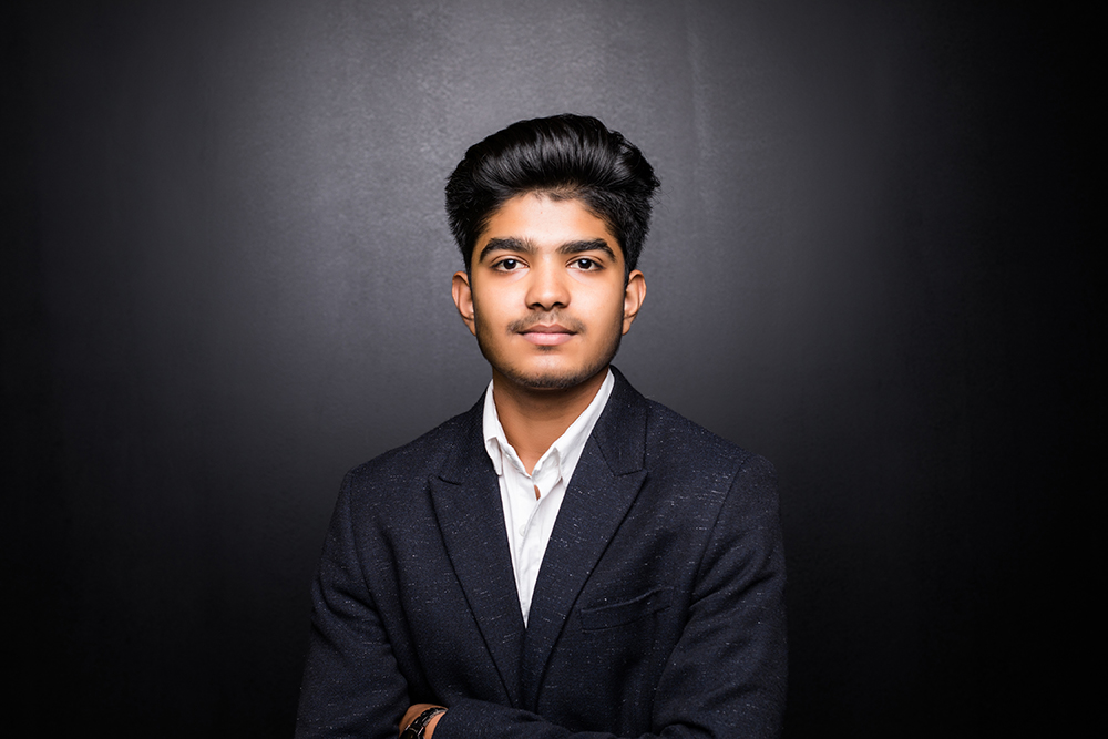 indian-business-man-with-crossed-arm-dark-wall