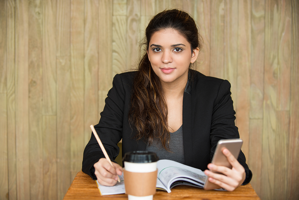 smiling-female-student-doing-homework-desk